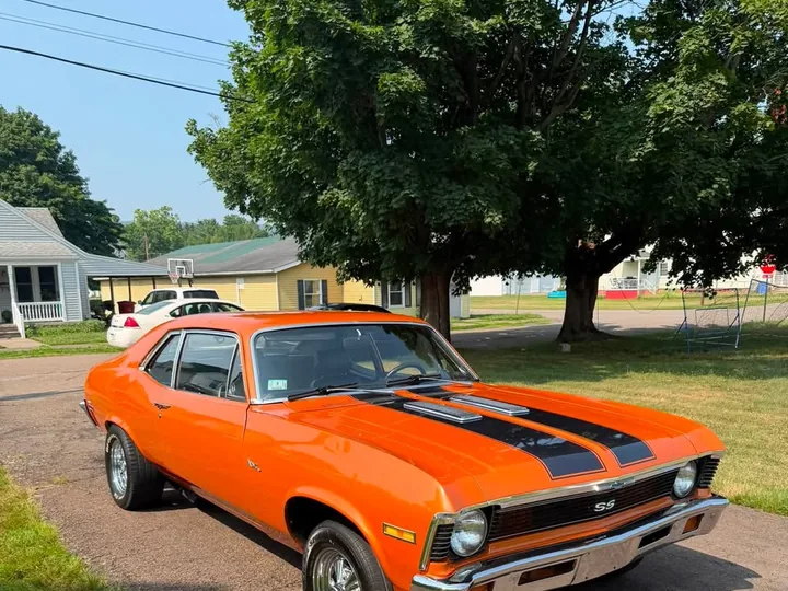 Orange classic Chevrolet Nova with a clean, reflective exterior